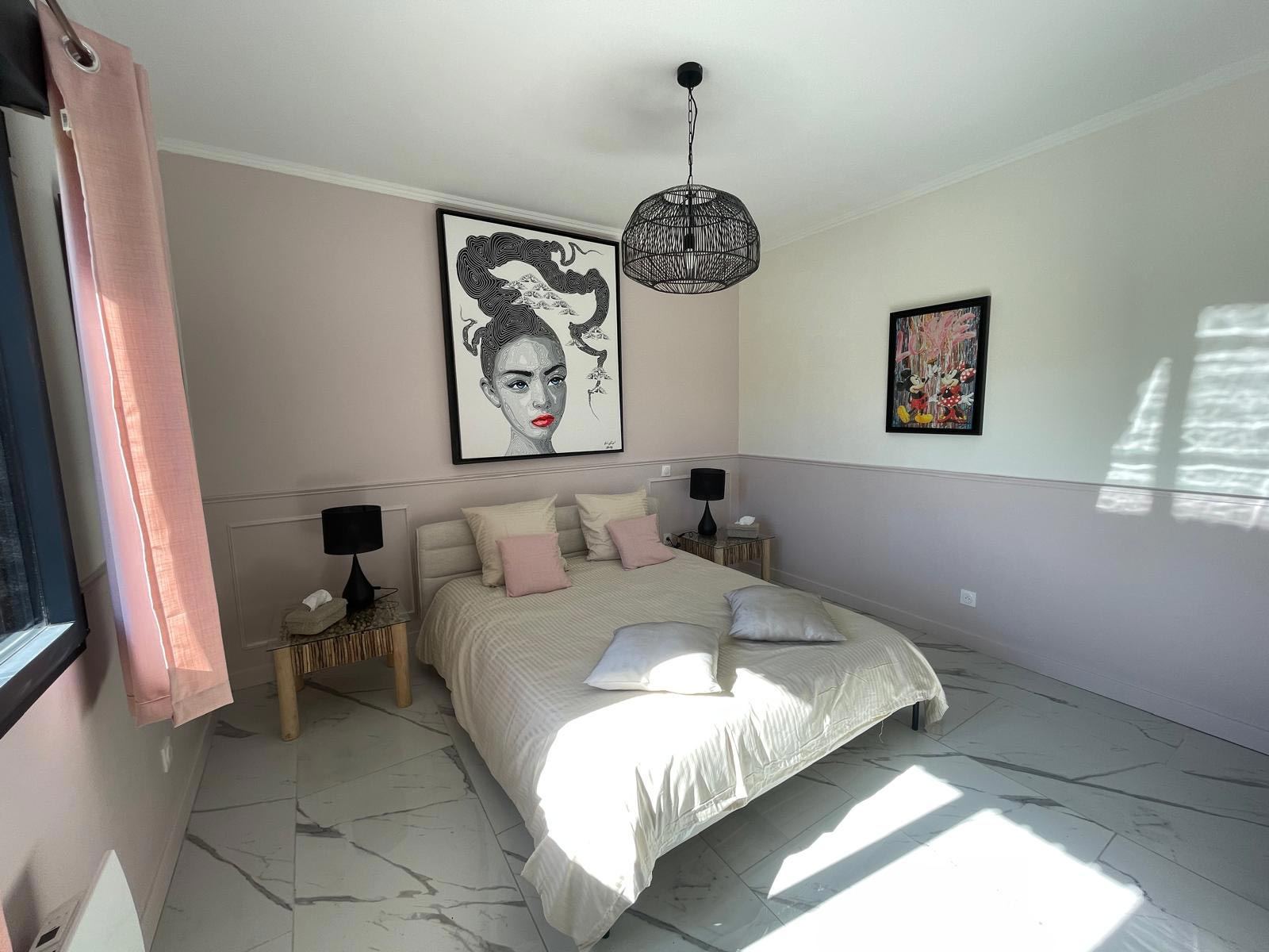 Chambre Muse : lit double, murs rose pâle et portrait artistique