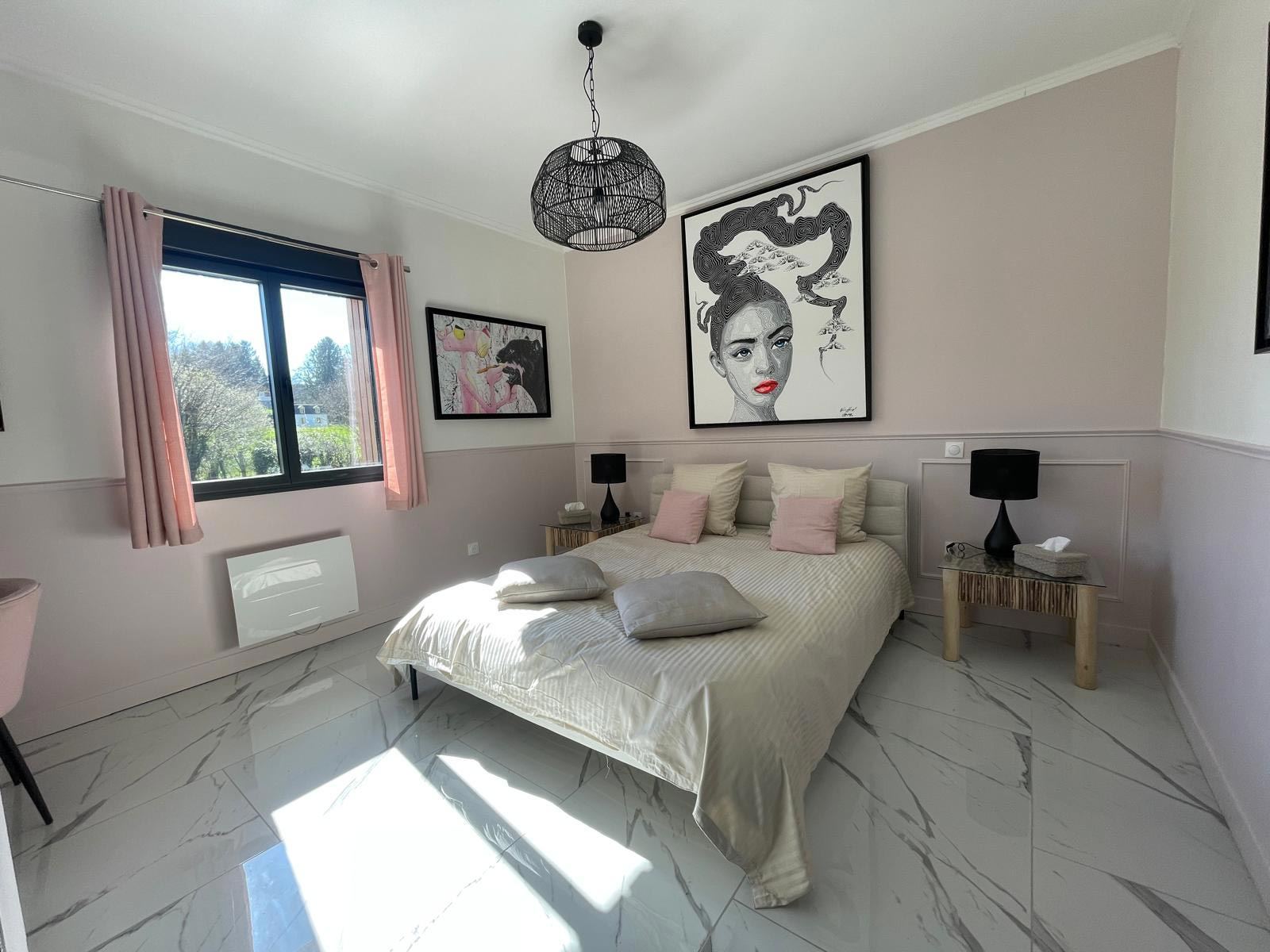 Chambre Muse lumineuse avec fenêtre sur le jardin et lit double aux coussins roses